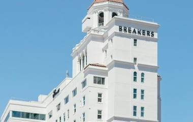 The Fairmont Breakers building, tall and white with a terracotta roof, against a bright blue sky.