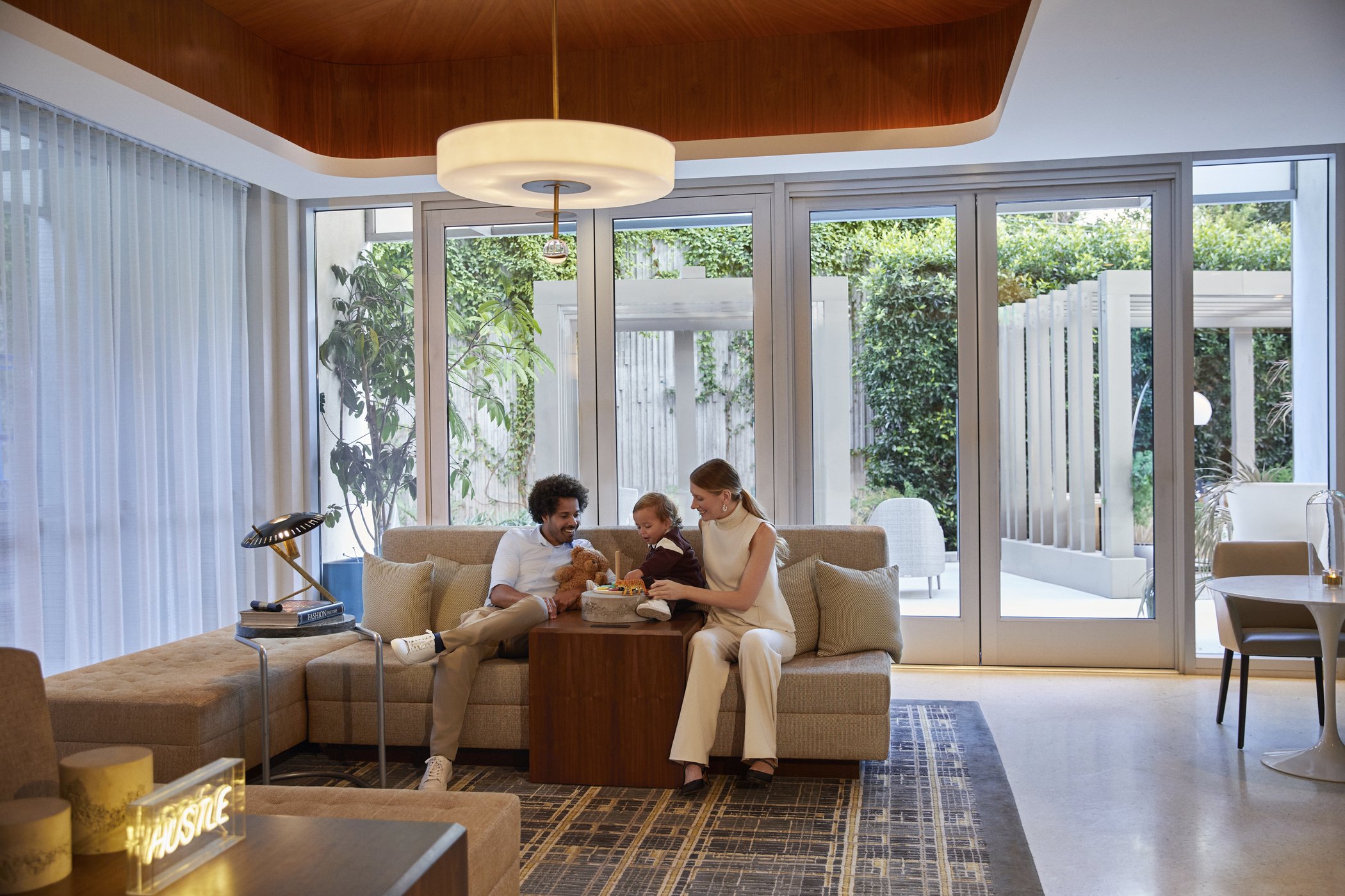 A family sits on a couch in an airing living area.