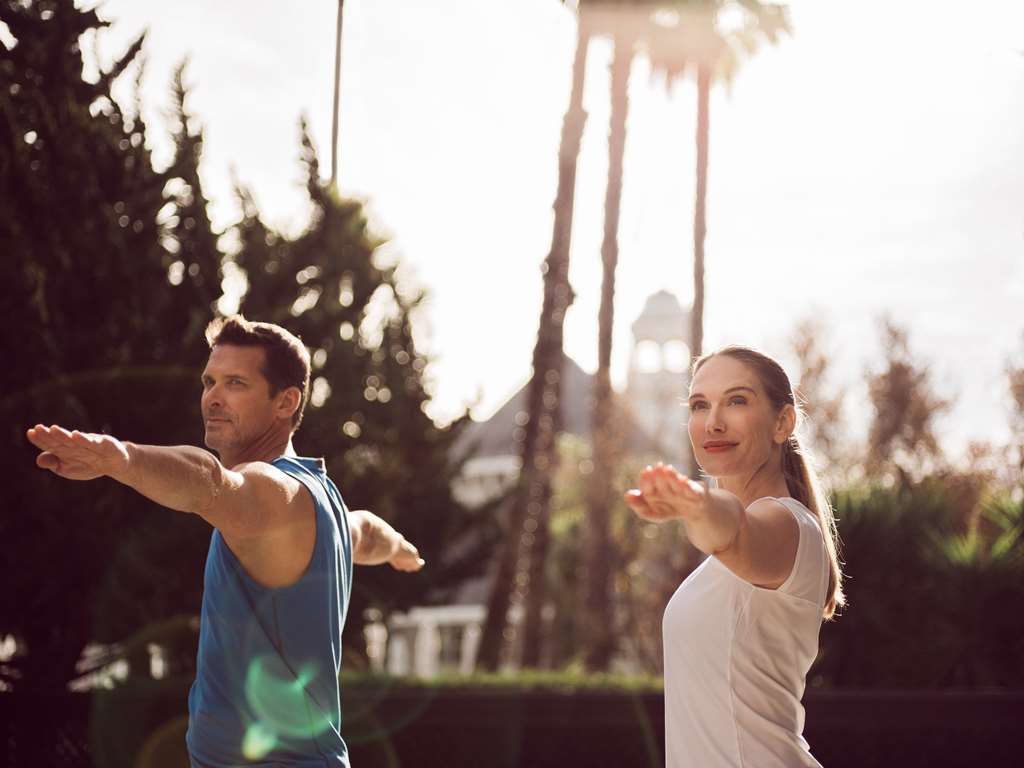 A man and a woman doing yoga in the sunshine.