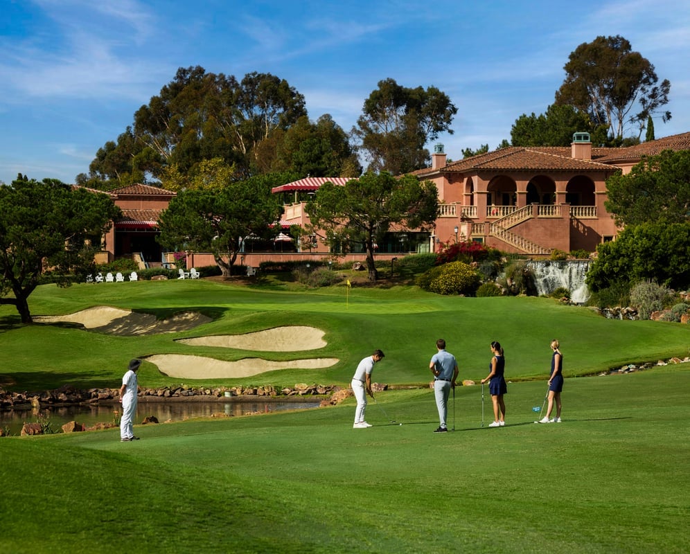 A group watches a golfer line up his shot on the green at Fairmont Grand Del Mar.