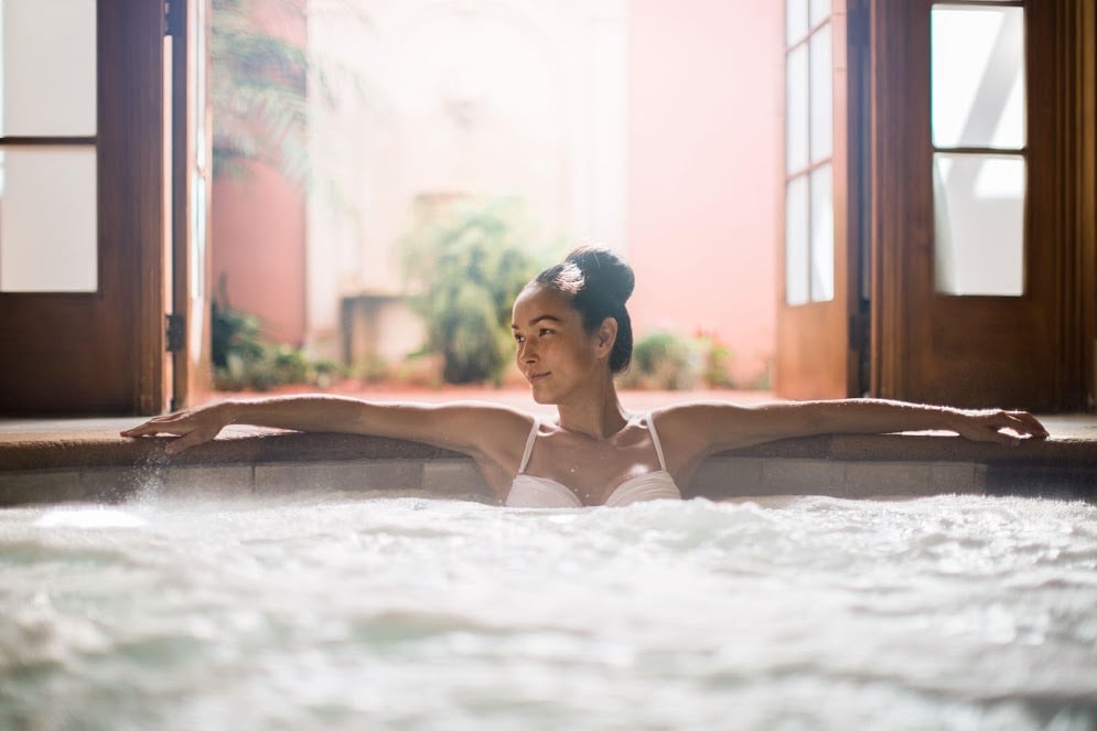 A woman sits in a jacuzzi.