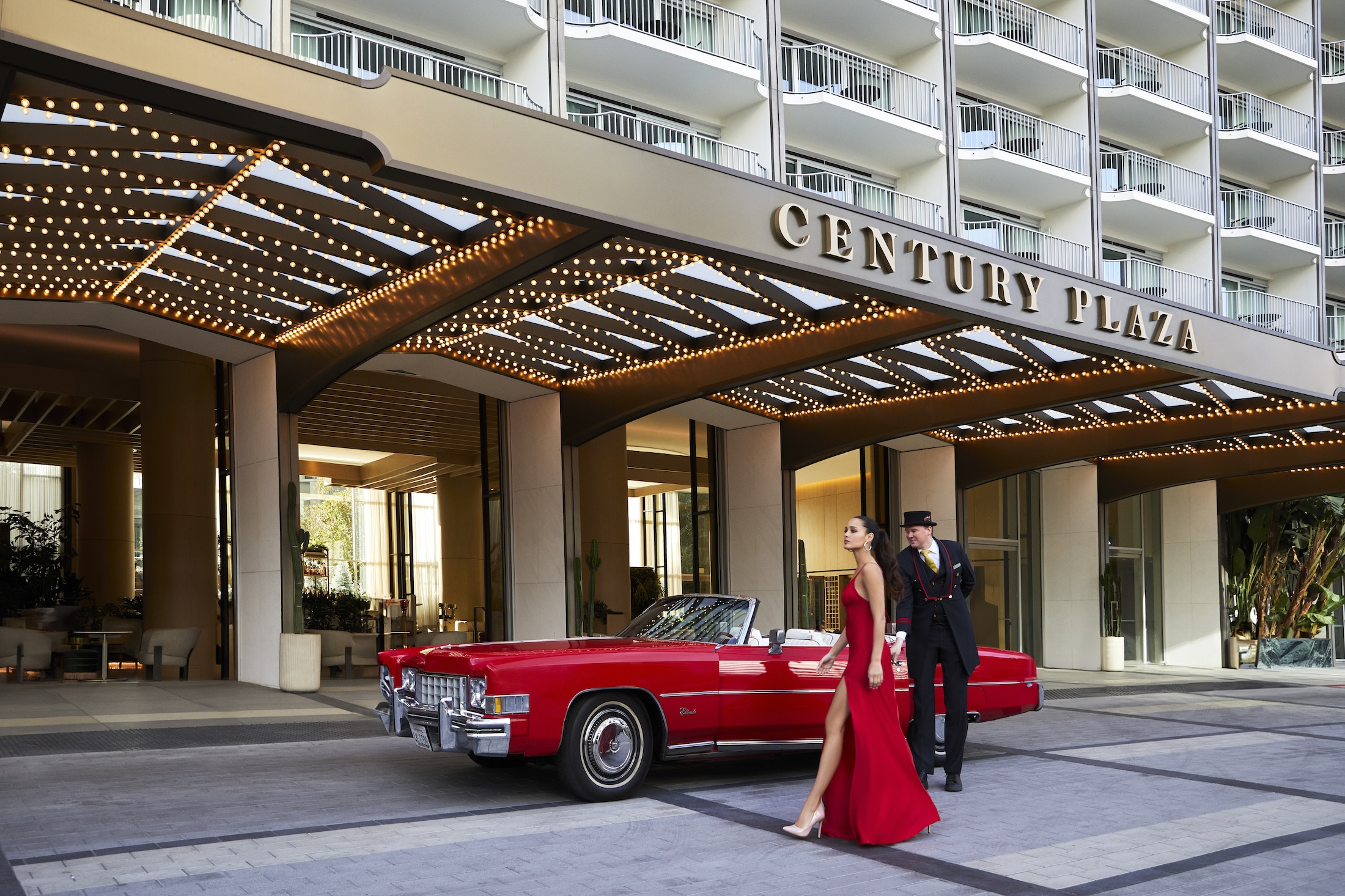 A woman in a red gown drops her red convertible off with the valet outside Fairmont Century Plaza.